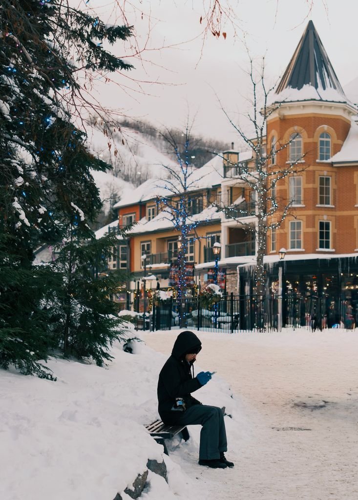 Winter ambiance in Blue Mountain Village, Ontario with snow and festive lights.